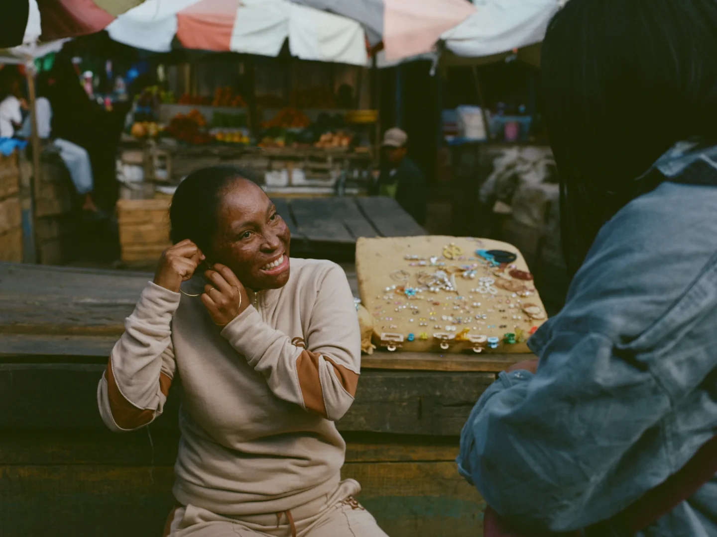 Gladys enjoys a sunny day in the market, trying on jewelry.