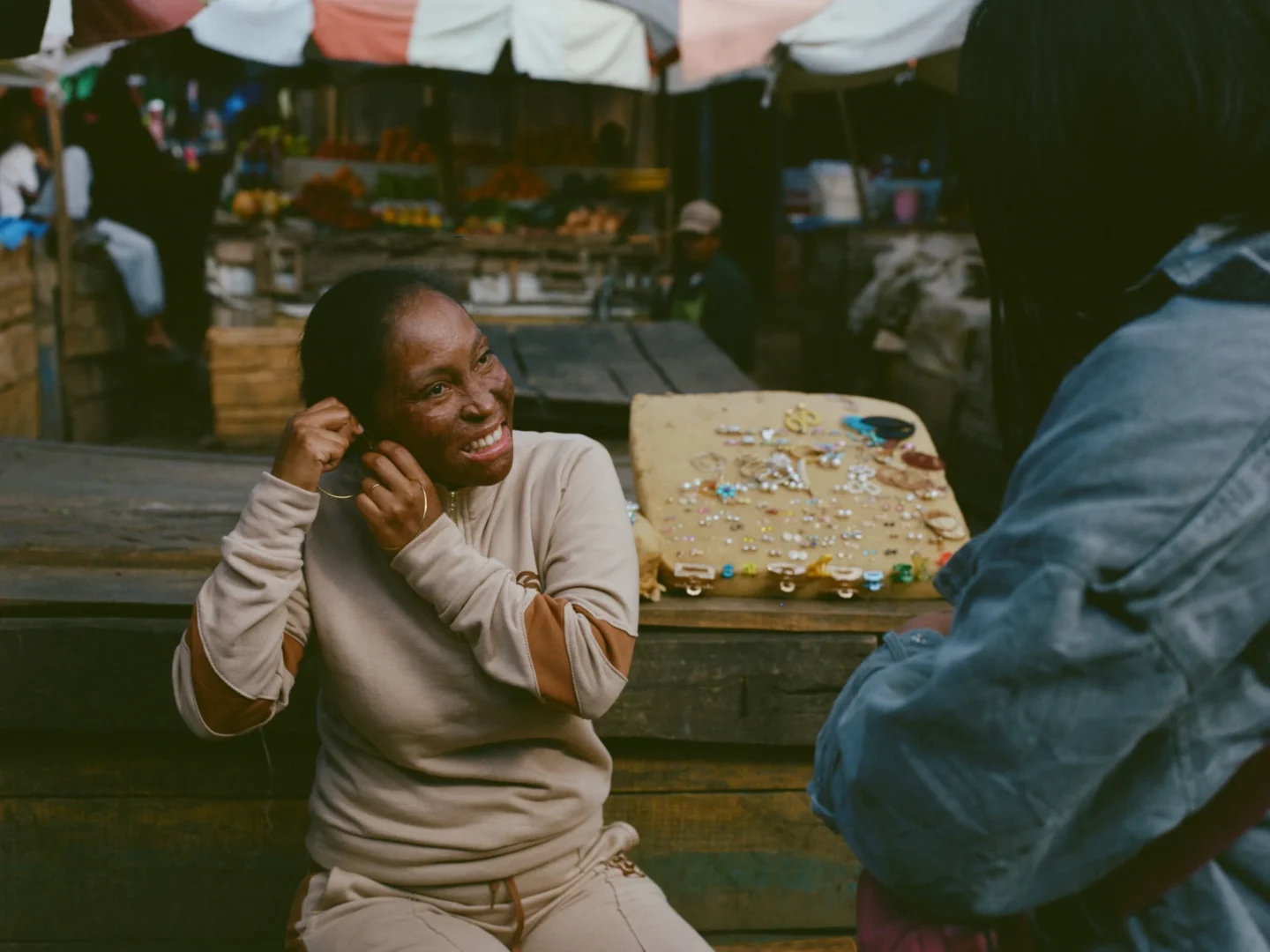 Gladys enjoys a sunny day in the market, trying on jewelry.